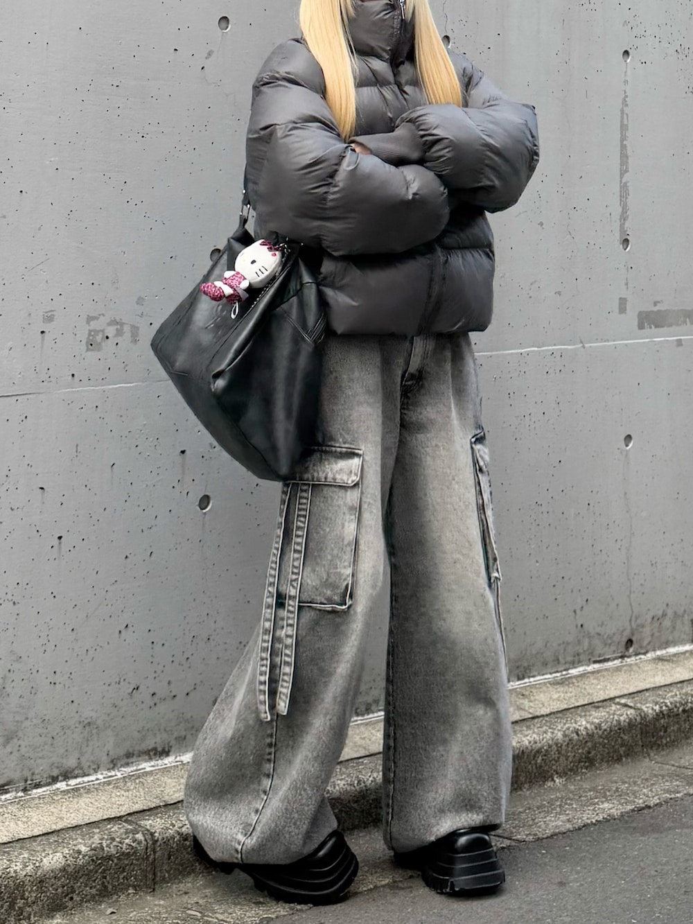 グレー系のダウンジャケット/コート、グレー系のデニムパンツ、ブラック系のボストンバッグを着用したレディースの冬コーディネートの3枚目の写真