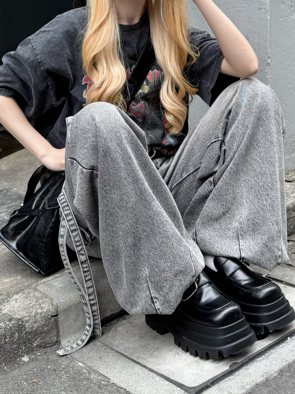 グレー系のデニムパンツ、ブラック系のTシャツ/カットソー、ブラック系のショルダーバッグを着用したレディースの夏コーディネートの3枚目の写真