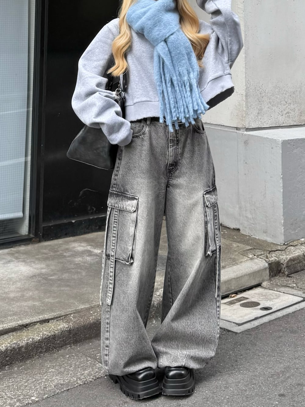 グレー系のスウェット、グレー系のデニムパンツ、ブラック系のボストンバッグを着用したレディースの冬コーディネートの4枚目の写真