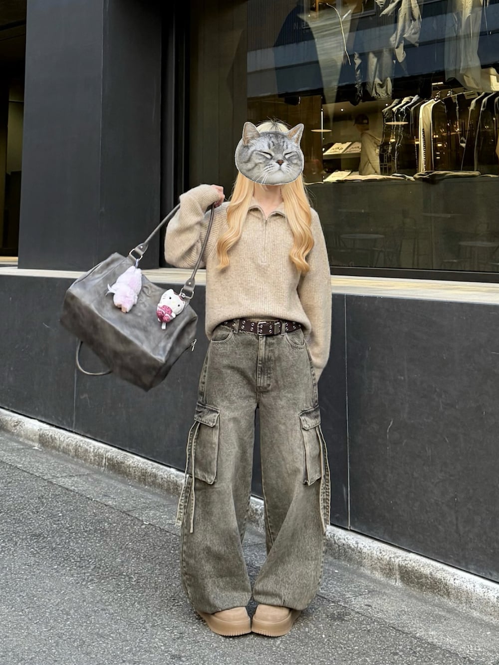 ベージュ系のニット/セーター、グレー系のボストンバッグ、ブラウン系のデニムパンツを着用したレディースの冬コーディネートの2枚目の写真