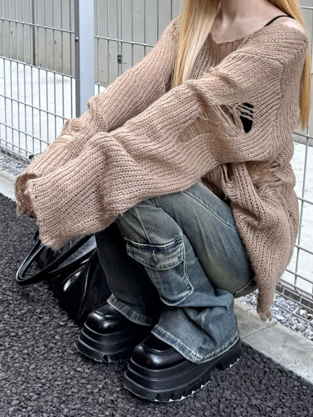 ブルー系のデニムパンツ、ブラック系のボストンバッグ、ベージュ系のニット/セーターを着用したレディースの秋コーディネートの4枚目の写真