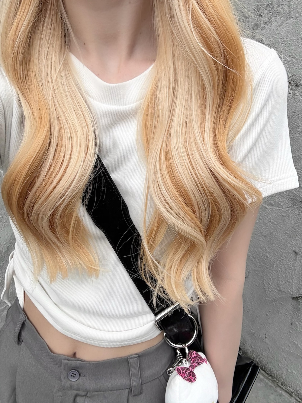 ホワイト系のTシャツ/カットソー、グレー系のスラックス、ブラック系のローファーを着用したレディースの夏コーディネートの3枚目の写真