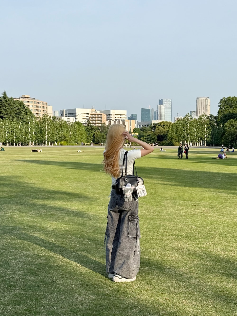 ホワイト系のTシャツ/カットソー、グレー系のデニムパンツ、ホワイト系のスニーカーを着用したレディースの春コーディネートの3枚目の写真