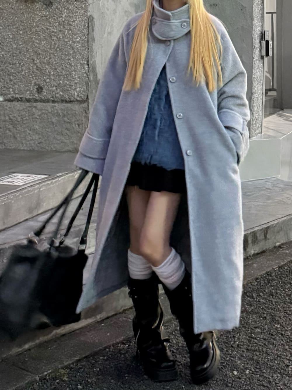 ブルー系のカーディガン/ボレロ、ブラック系のスカート、ブラック系のボストンバッグを着用したレディースの冬コーディネートの4枚目の写真