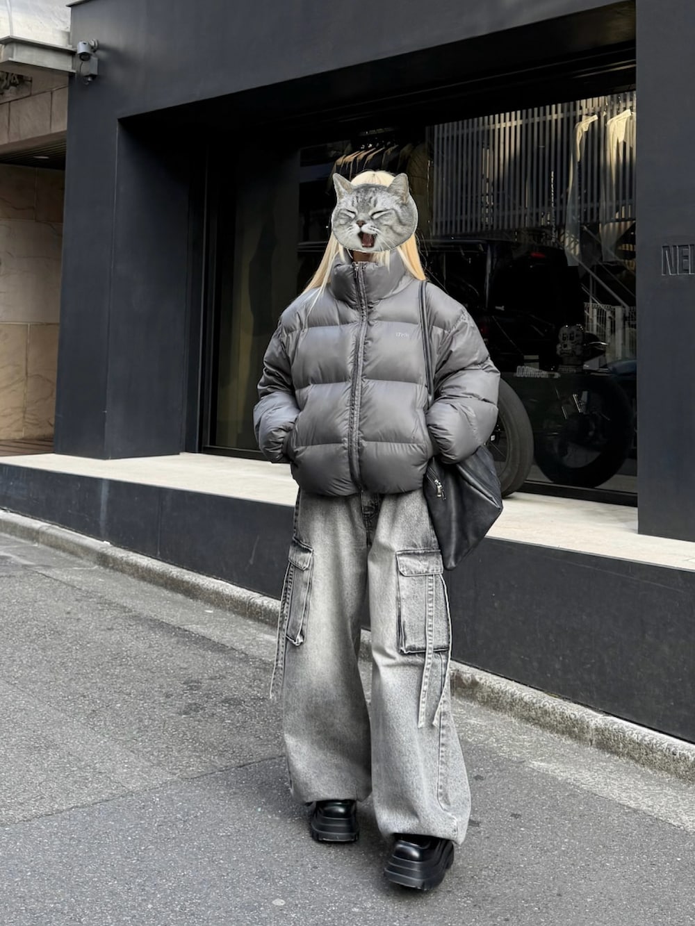 グレー系のダウンジャケット/コート、グレー系のデニムパンツ、ブラック系のボストンバッグを着用したレディースの冬コーディネートの4枚目の写真