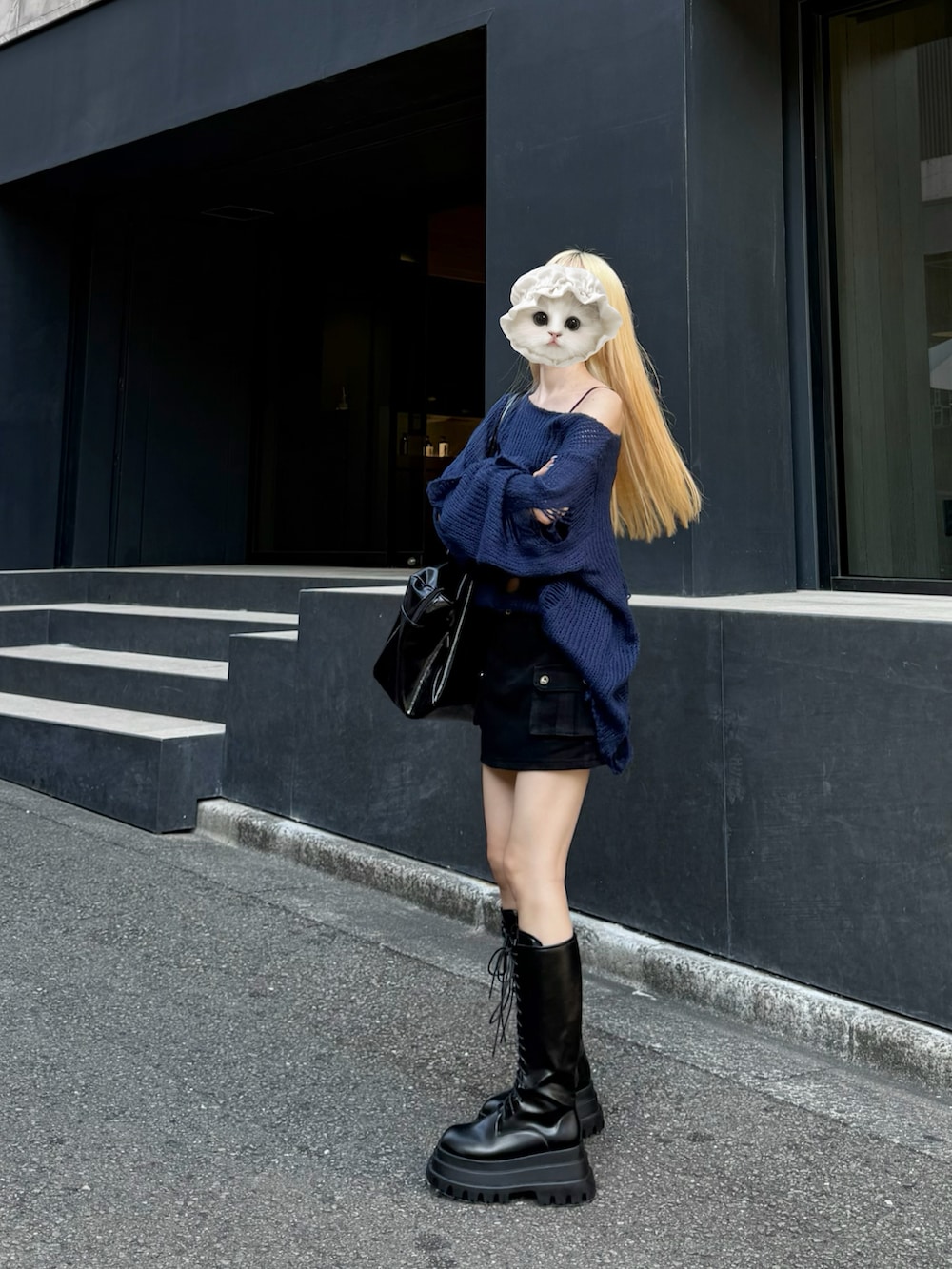 ブラック系のブーツ、ブルー系のニット/セーター、ブラック系のスカートを着用したレディースの秋コーディネートの4枚目の写真