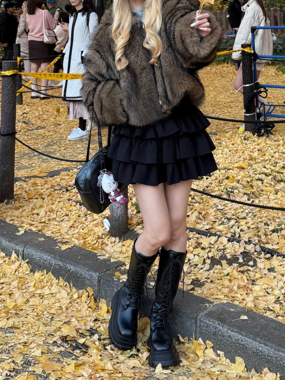 ブラウン系のその他アウター、ブラック系のスカート、ブラック系のブーツを着用したレディースの冬コーディネートの3枚目の写真