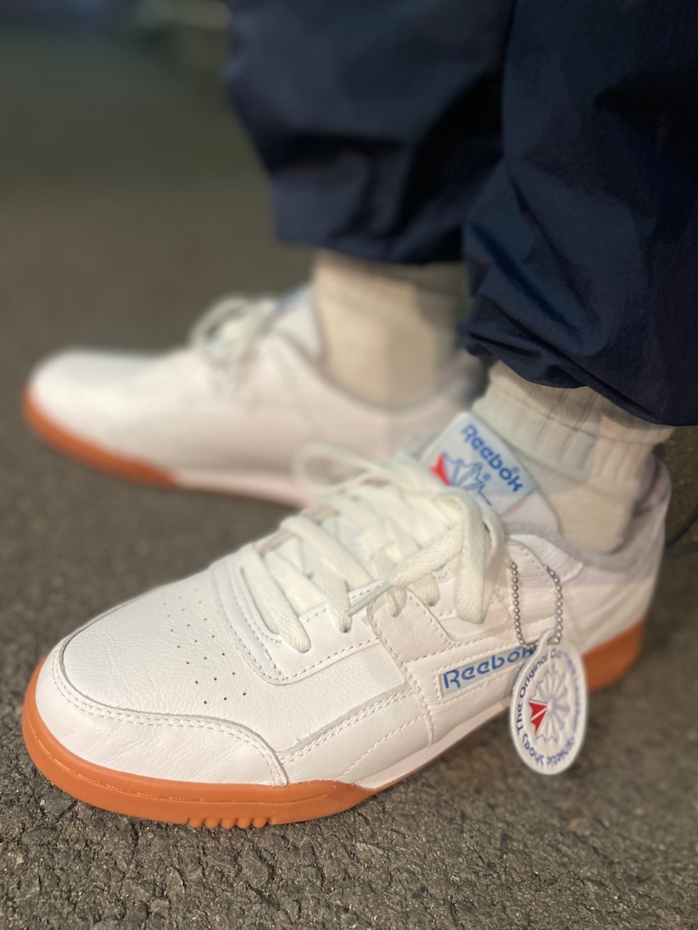 ホワイト系のスニーカー、ブルー系のナイロンジャケット、ブルー系のその他パンツを着用したメンズの冬コーディネートの2枚目の写真