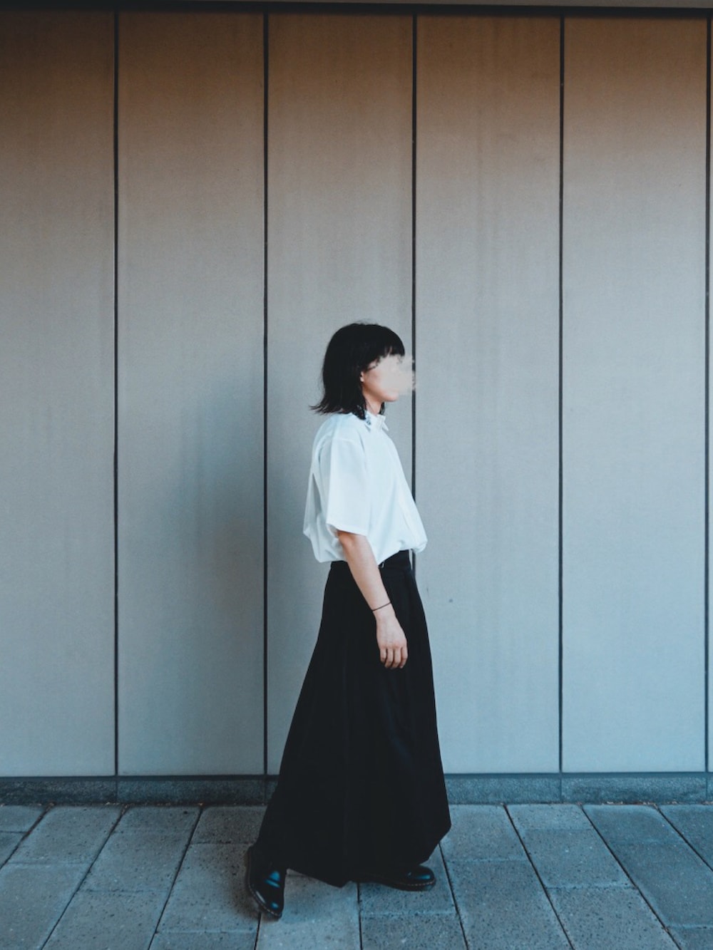 ブラック系のスカート、ホワイト系のシャツ/ブラウス、ブラック系のブーツを着用したメンズの夏コーディネートの2枚目の写真