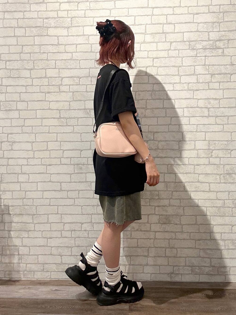 ブラック系のサンダル、ブラック系のワンピース、ピンク系のショルダーバッグを着用したレディースの夏コーディネートの2枚目の写真