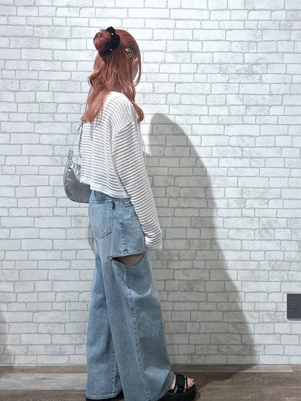 シルバー系のショルダーバッグ、その他のサンダル、ブルー系のデニムパンツを着用したレディースの夏コーディネートの4枚目の写真