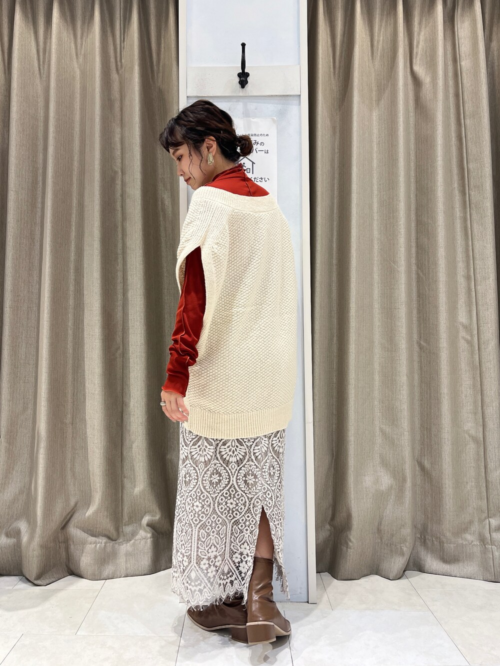 ホワイト系のベスト、レッド系のTシャツ/カットソー、ホワイト系のスカートを着用したレディースの秋コーディネートの3枚目の写真