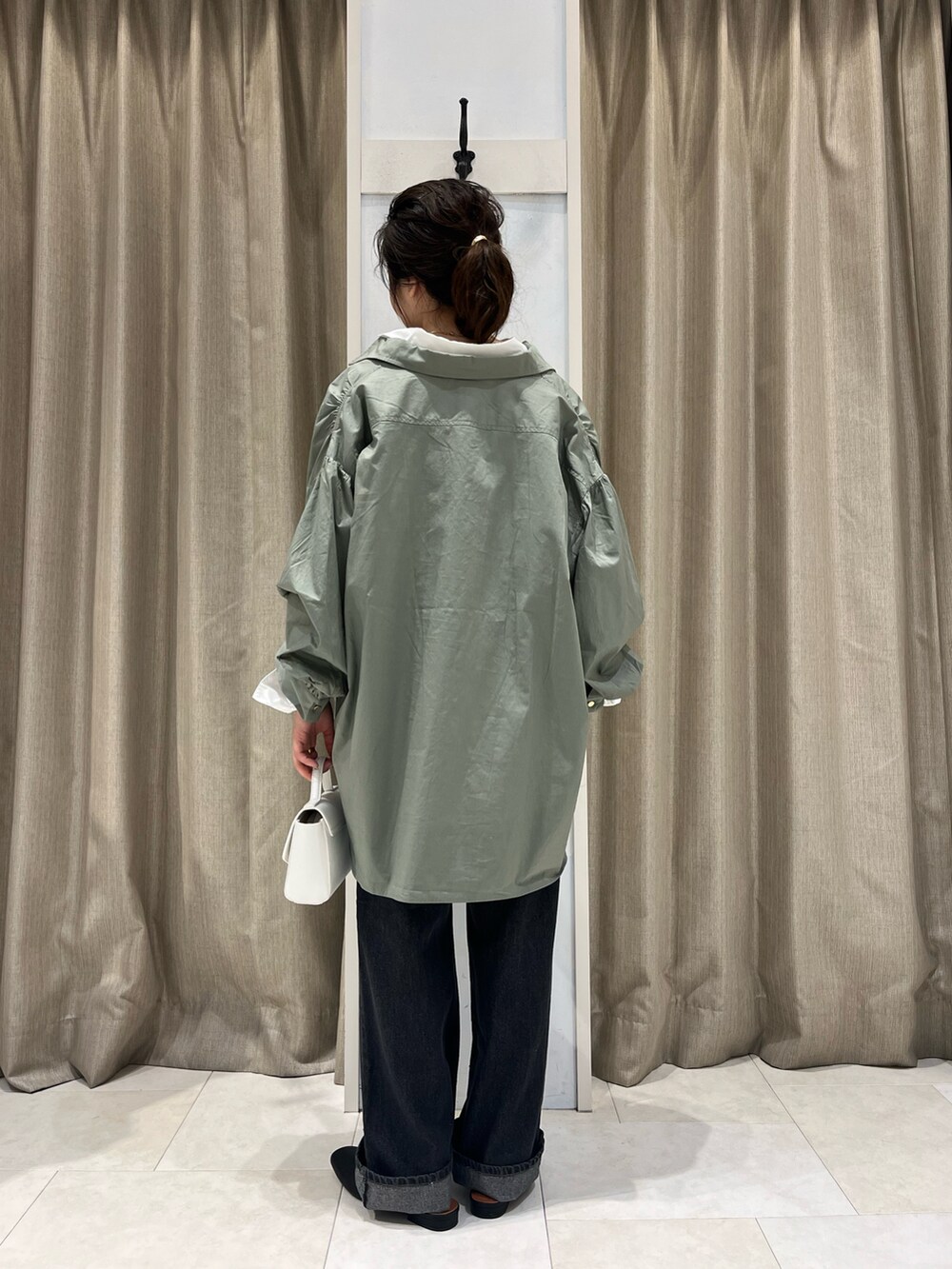 グリーン系のシャツ/ブラウス、ホワイト系のシャツ/ブラウス、ホワイト系のハンドバッグを着用したレディースの春コーディネートの3枚目の写真