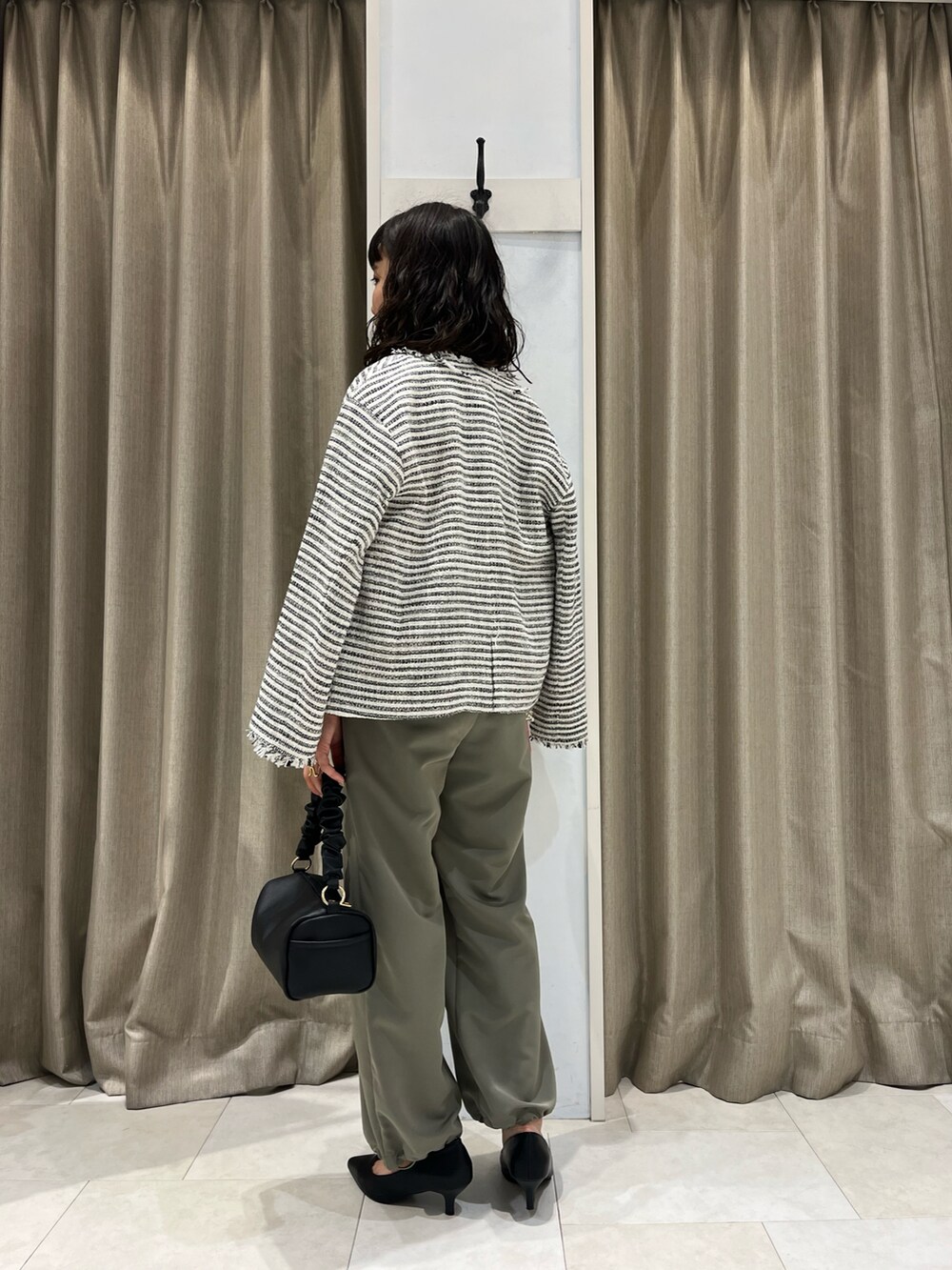 ホワイト系のTシャツ/カットソー、ブラック系のノーカラージャケット、グリーン系のその他パンツを着用したレディースの春コーディネートの2枚目の写真