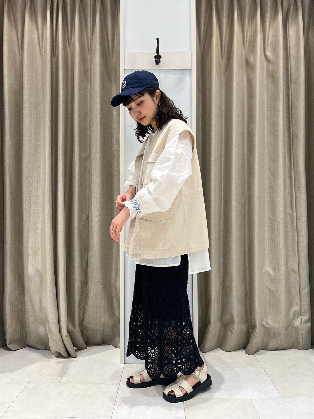 ホワイト系のシャツ/ブラウス、ベージュ系のベスト、ブラック系のスカートを着用したレディースの春コーディネートの2枚目の写真