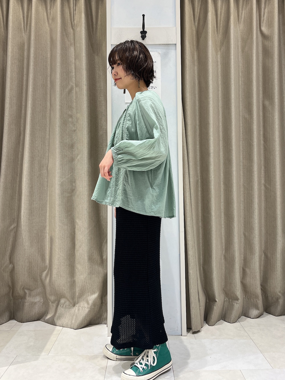 グリーン系のシャツ/ブラウス、ブラック系のスカート、グリーン系のスニーカーを着用したレディースの春コーディネートの2枚目の写真