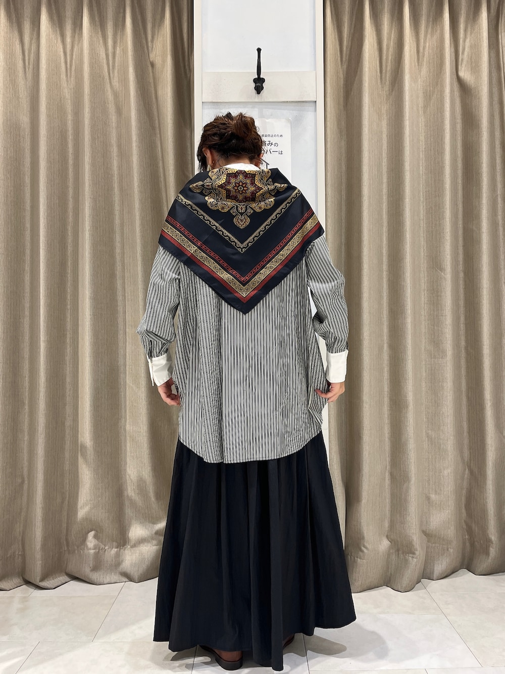 ブラック系のシャツ/ブラウス、ブラック系のスカート、ブラウン系のローファーを着用したレディースの秋コーディネートの2枚目の写真