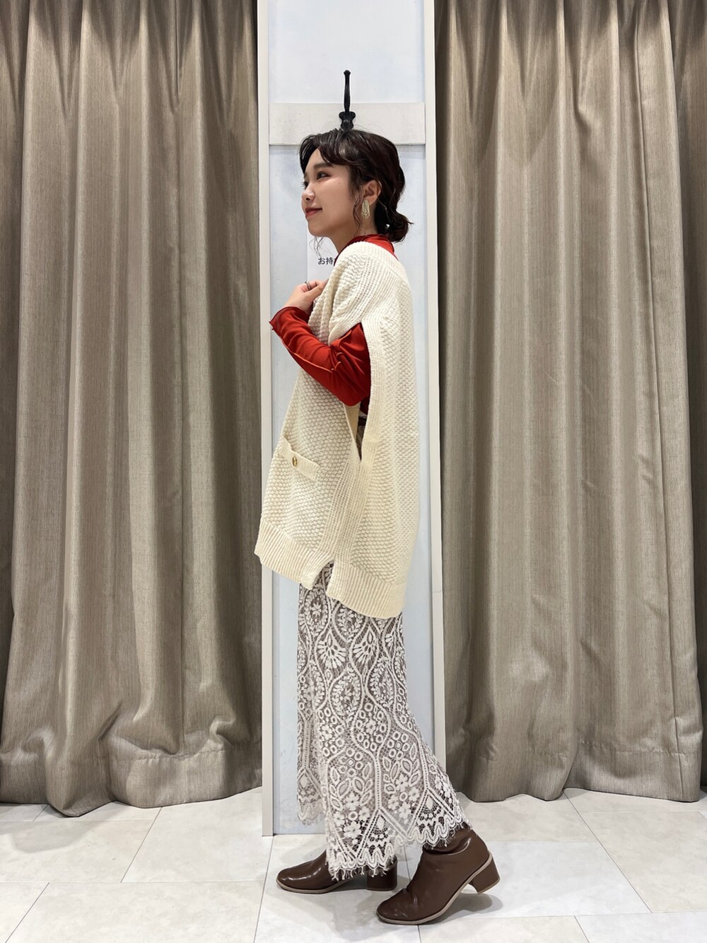 ホワイト系のベスト、レッド系のTシャツ/カットソー、ホワイト系のスカートを着用したレディースの秋コーディネートの2枚目の写真