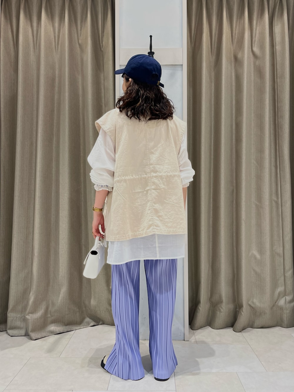 ベージュ系のベスト、ホワイト系のシャツ/ブラウス、パープル系のその他パンツを着用したレディースの春コーディネートの2枚目の写真