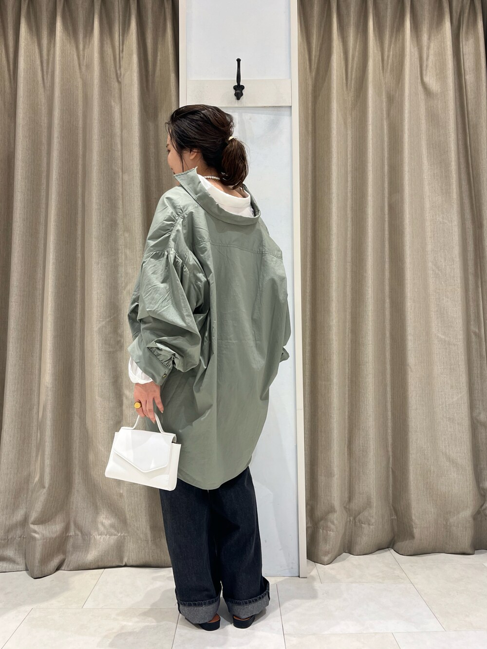 グリーン系のシャツ/ブラウス、ホワイト系のシャツ/ブラウス、ホワイト系のハンドバッグを着用したレディースの春コーディネートの2枚目の写真