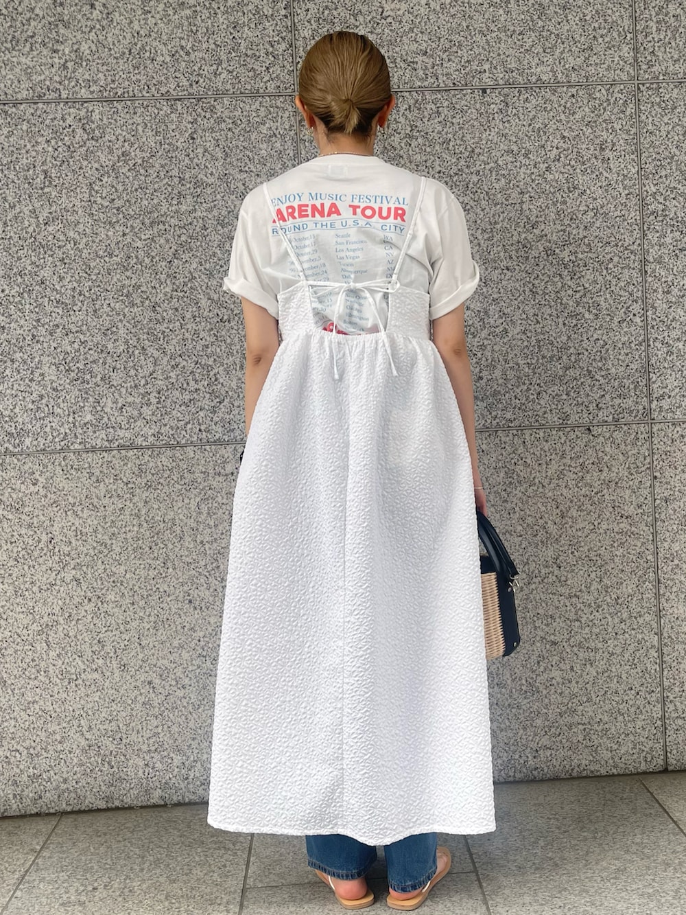 ホワイト系のワンピース、ブルー系のデニムパンツ、ベージュ系のバッグを着用したレディースの春コーディネートの3枚目の写真