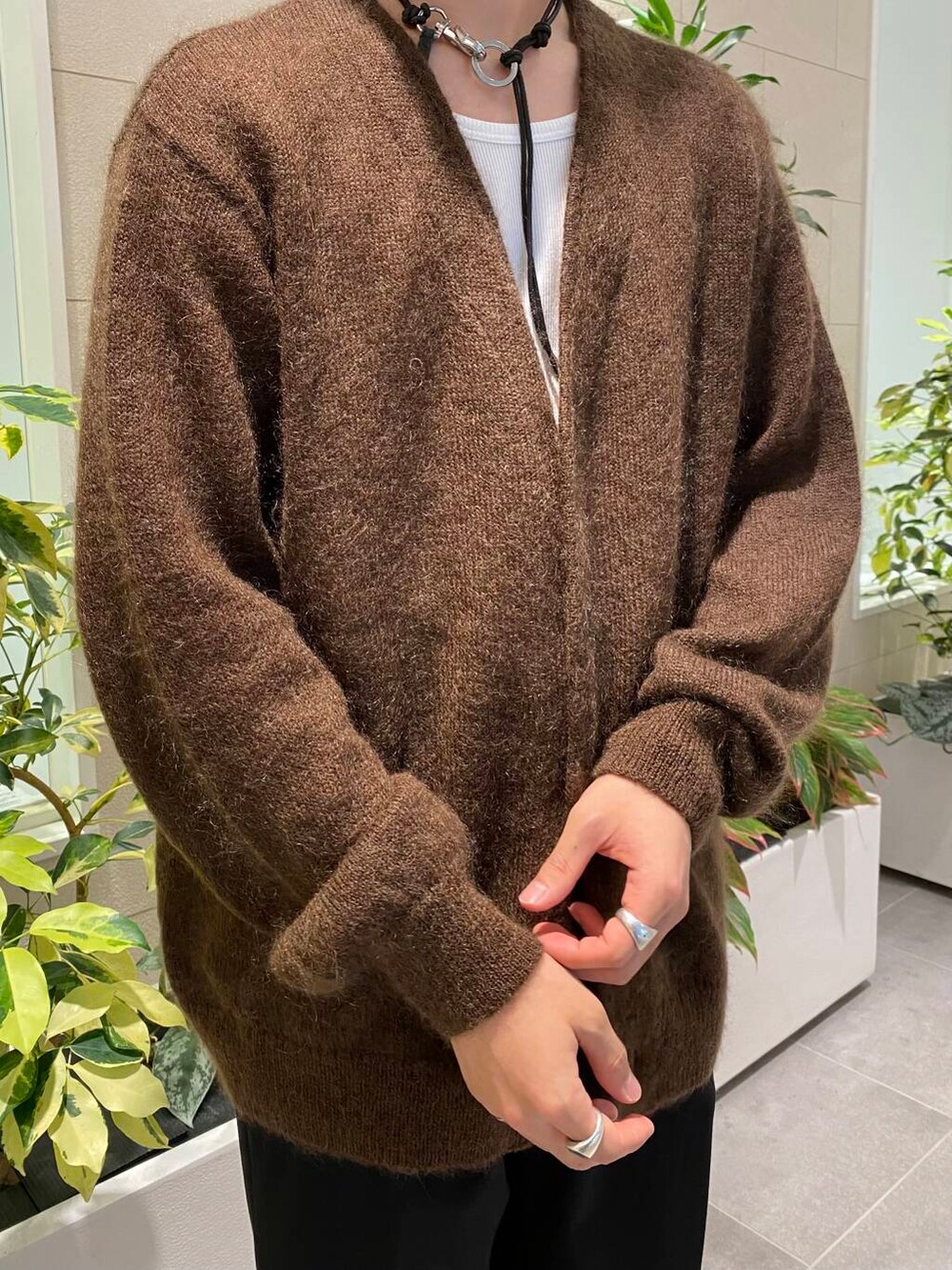 ブラック系のスラックス、ブラック系のスニーカー、ブラウン系のカーディガン/ボレロを着用したメンズの秋コーディネートの2枚目の写真