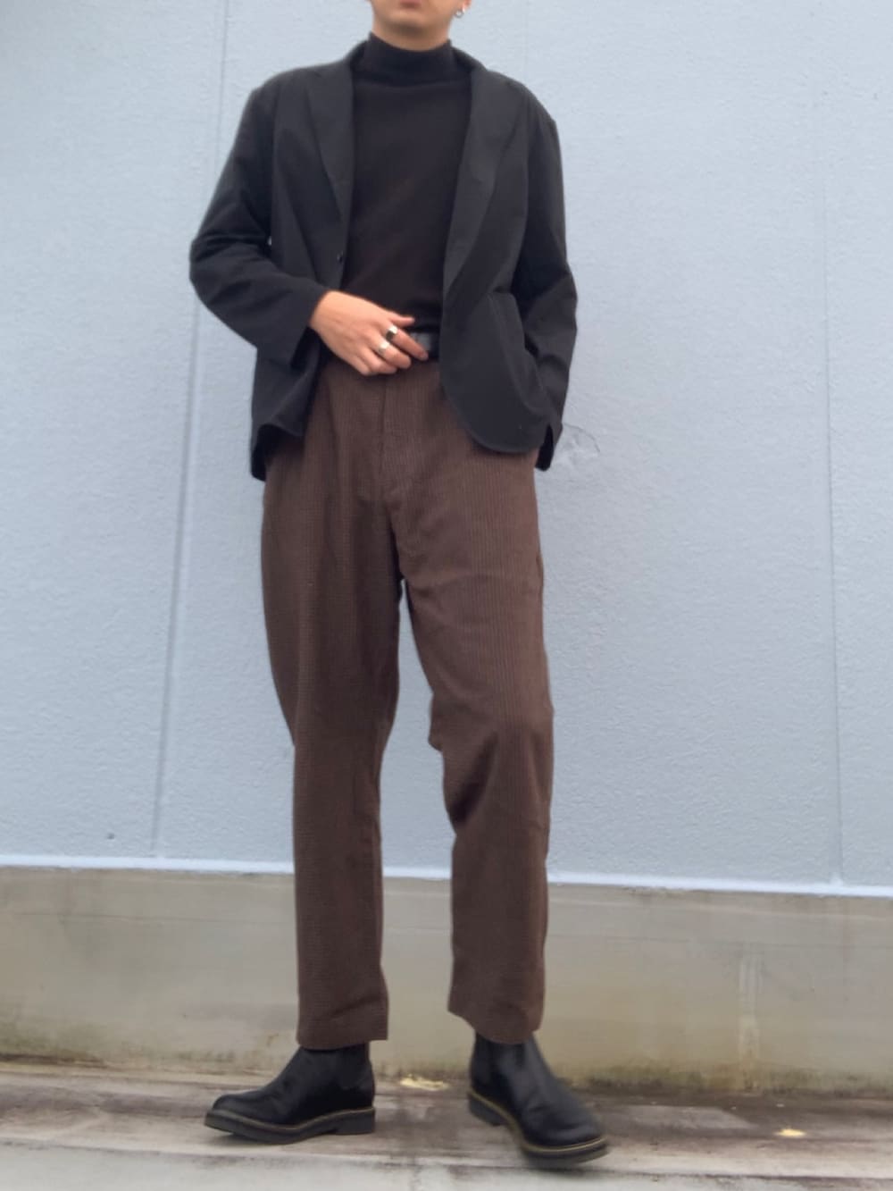 ブラック系のTシャツ/カットソー、ブラック系のジャケット/アウター、ブラウン系のスラックスを着用したメンズの冬コーディネートの3枚目の写真