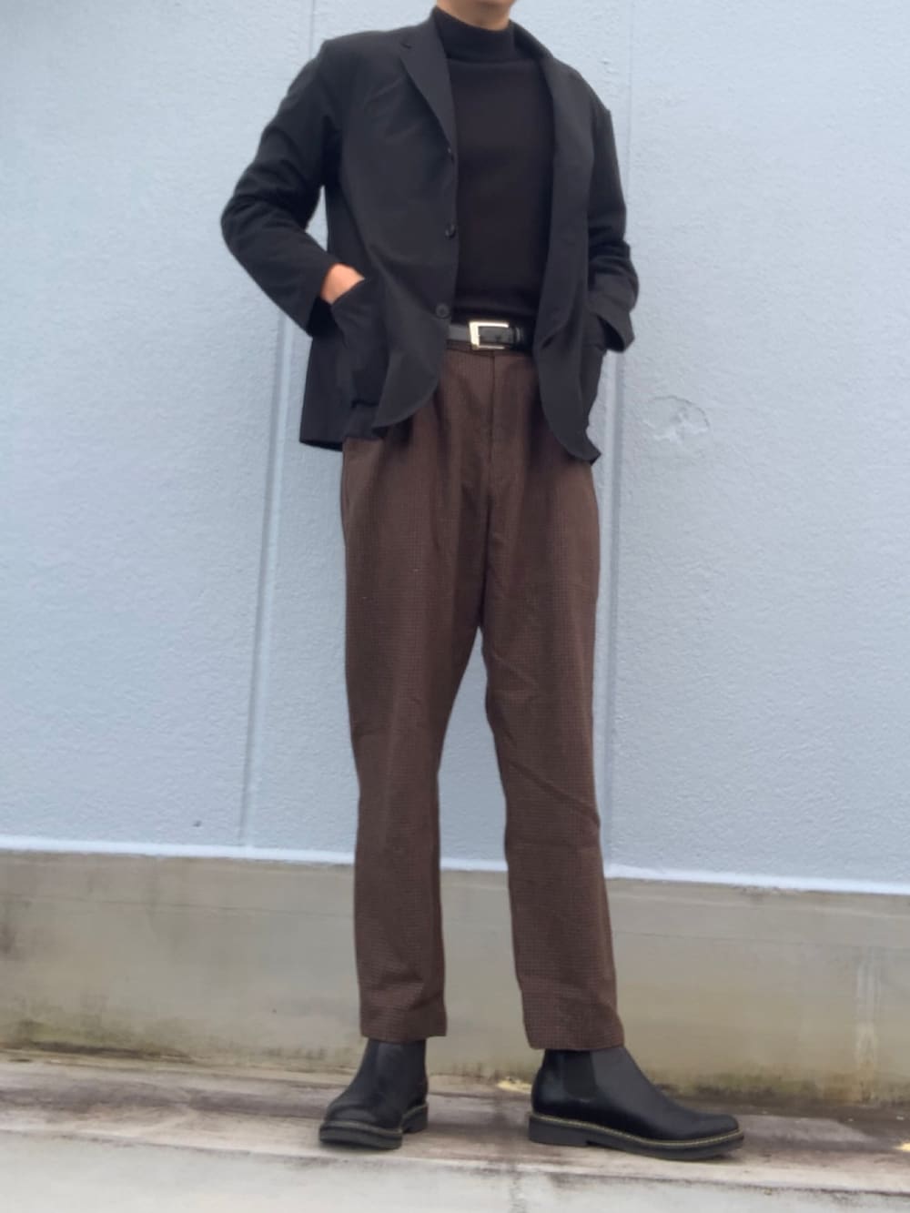 ブラック系のTシャツ/カットソー、ブラック系のジャケット/アウター、ブラウン系のスラックスを着用したメンズの冬コーディネートの2枚目の写真