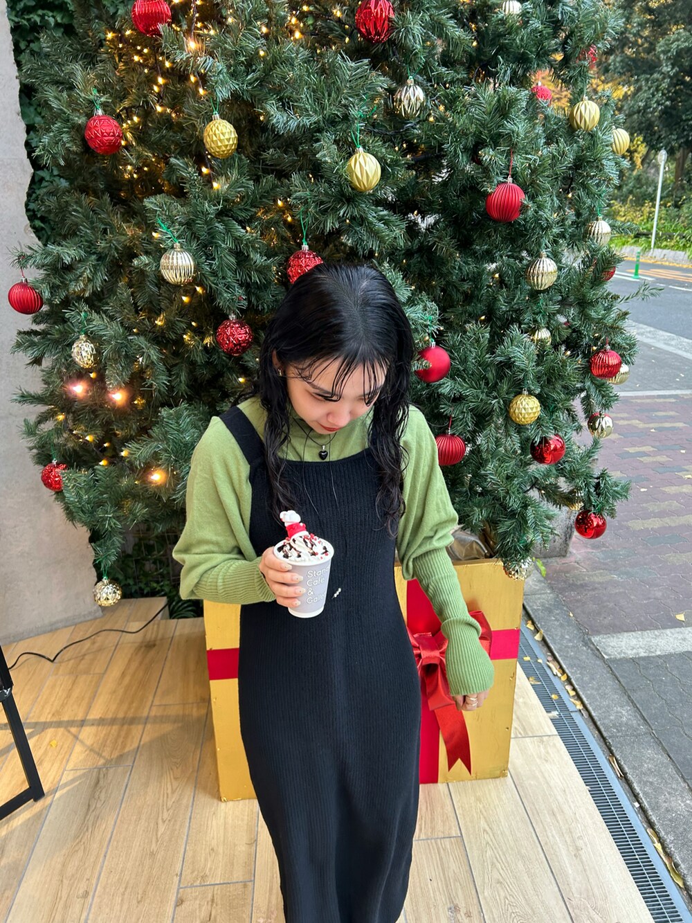 グリーン系のニット/セーター、ブラック系のワンピース、ブラック系のチョーカーを着用したレディースの冬コーディネートの2枚目の写真