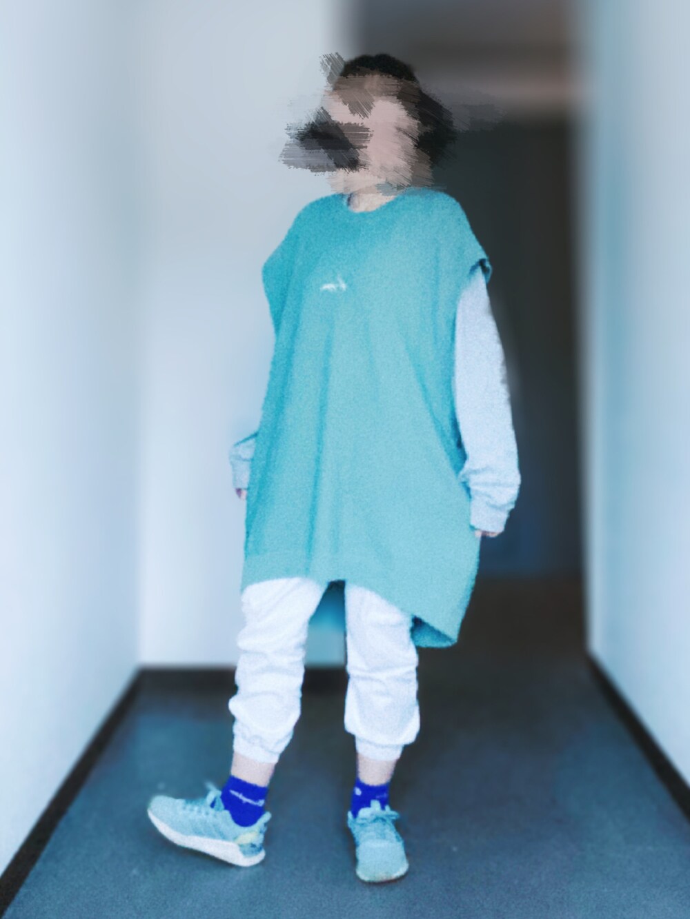 ホワイト系のデニムパンツ、ブルー系のベスト、グレー系のTシャツ/カットソーを着用したレディースの春コーディネートの2枚目の写真