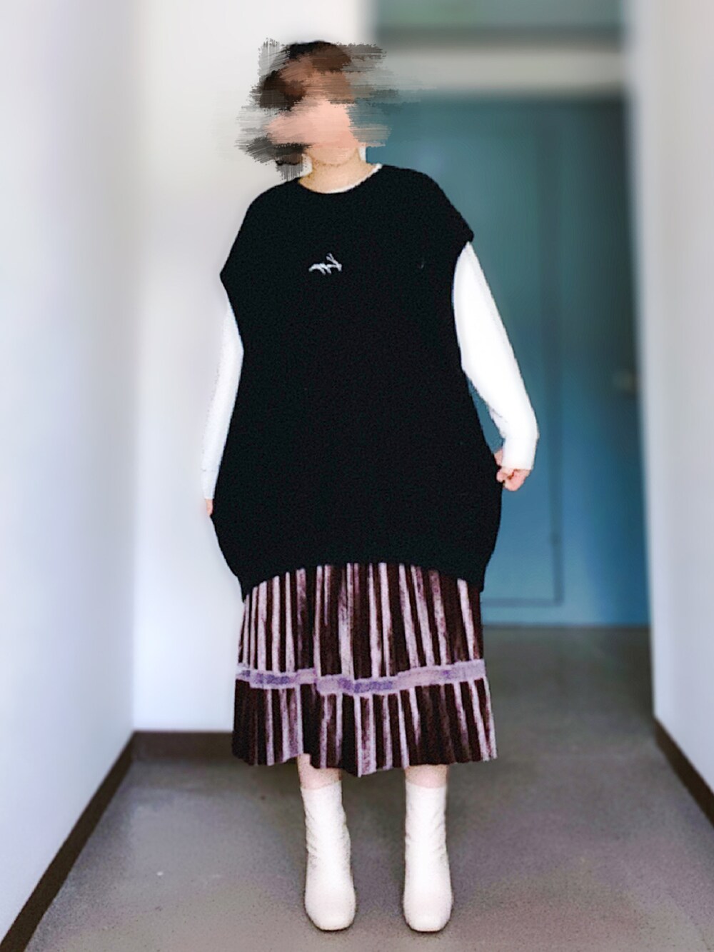 ブラック系のベスト、ブラウン系のスカート、グレー系のスウェットを着用したレディースの春コーディネートの2枚目の写真