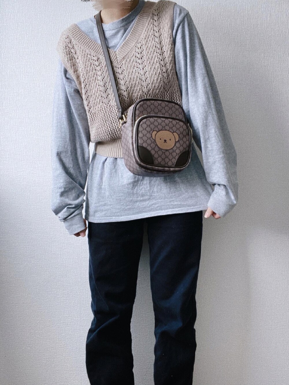 ブラック系のデニムパンツ、グレー系のTシャツ/カットソー、ブラウン系のショルダーバッグを着用したレディースの冬コーディネートの2枚目の写真