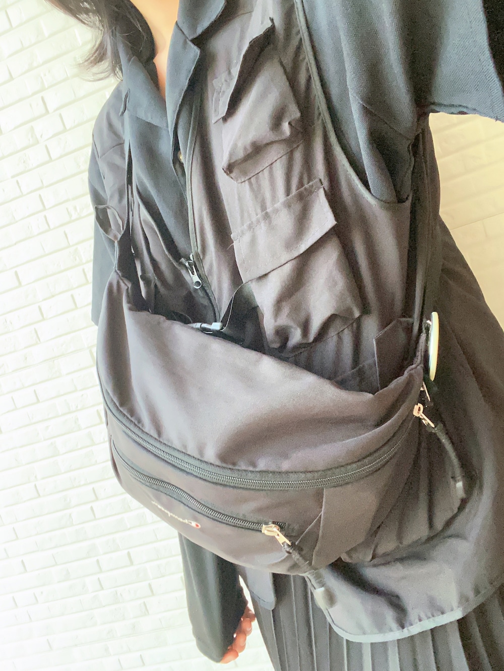 ブラック系のスカート、ブラック系のローファー、ブラック系のボディバッグ/ウエストポーチを着用したレディースの春コーディネートの2枚目の写真