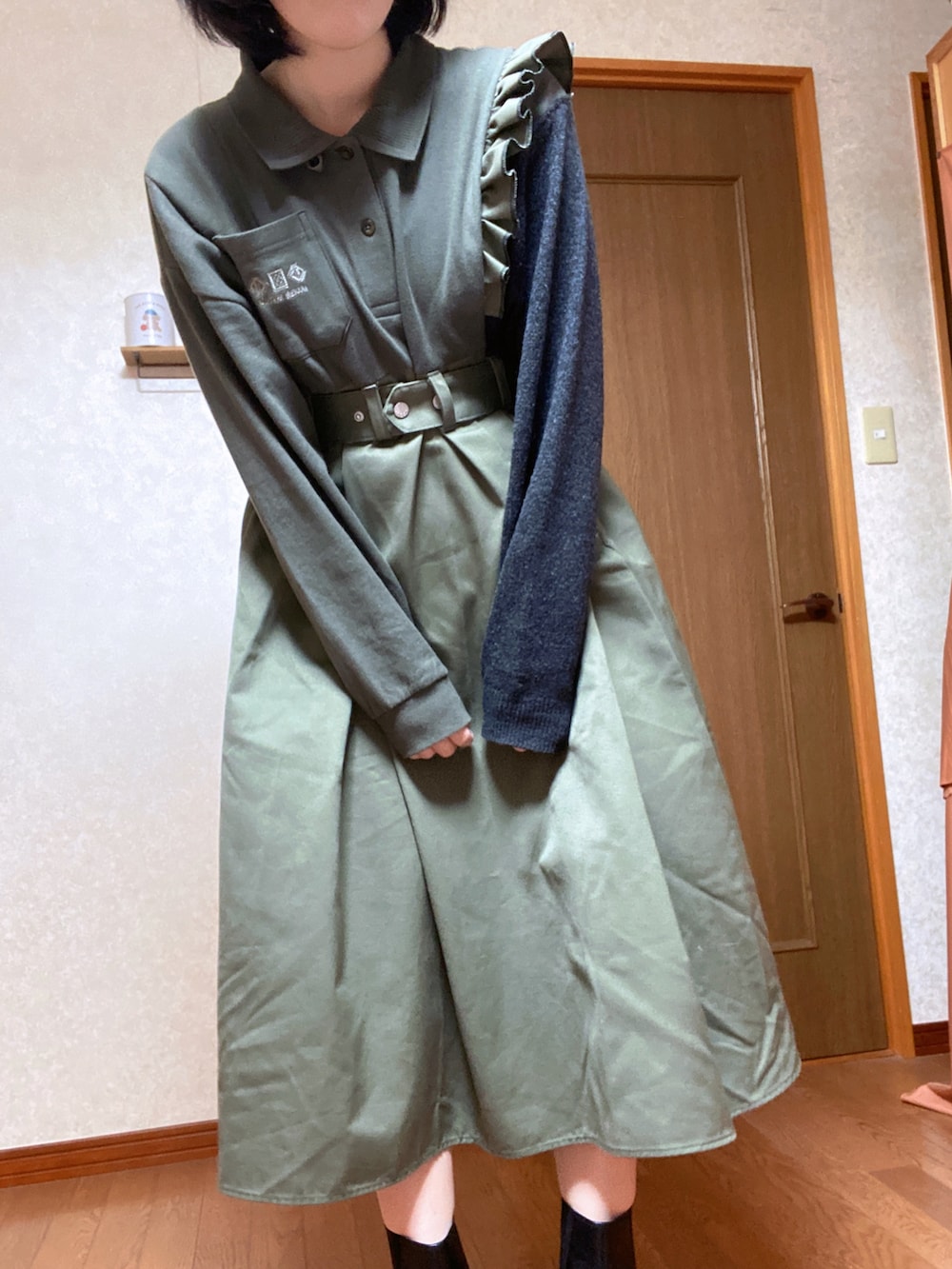 グリーン系のワンピース、ブラック系のブーツを着用したレディースの秋コーディネートの2枚目の写真