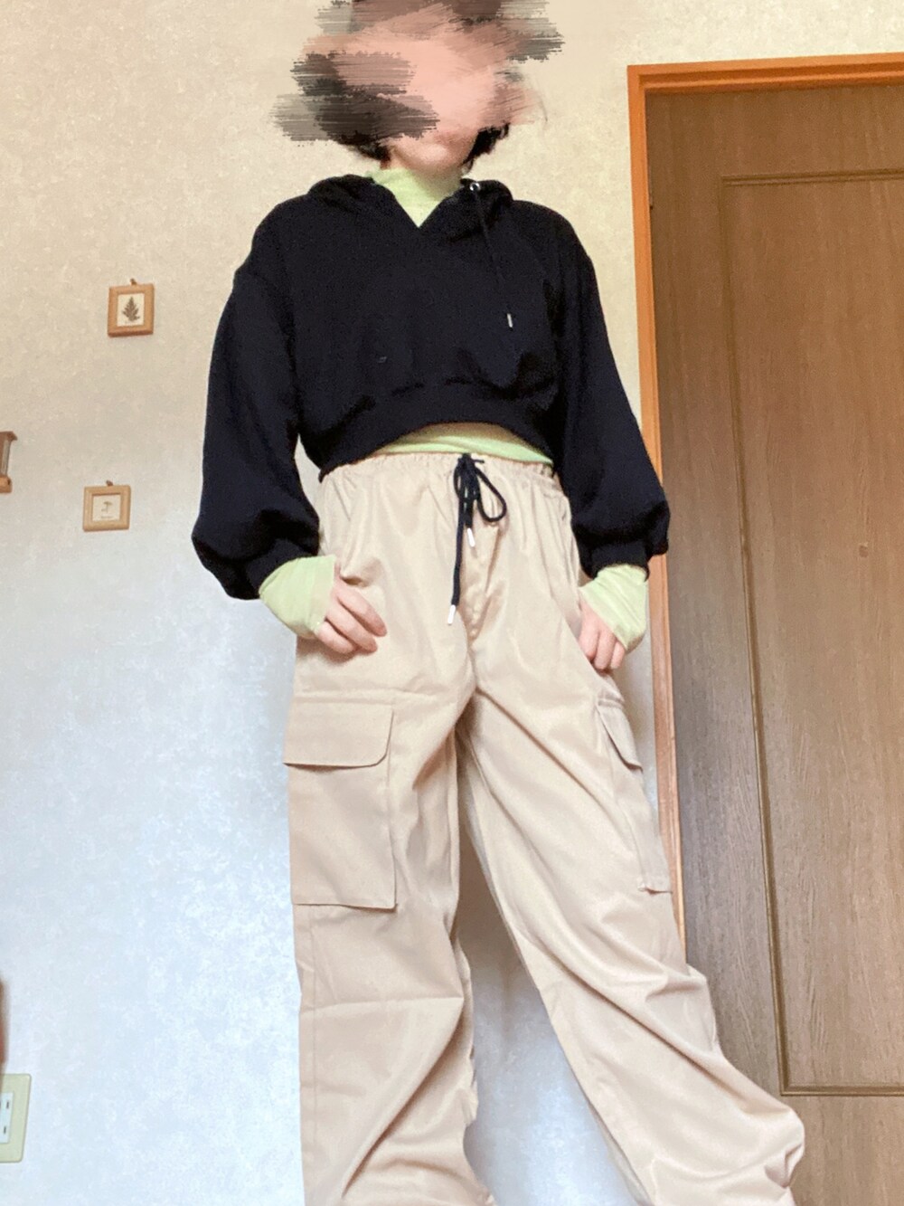 ベージュ系のカーゴパンツ、ブラック系のパーカー、グリーン系のTシャツ/カットソーを着用したレディースの秋コーディネートの2枚目の写真