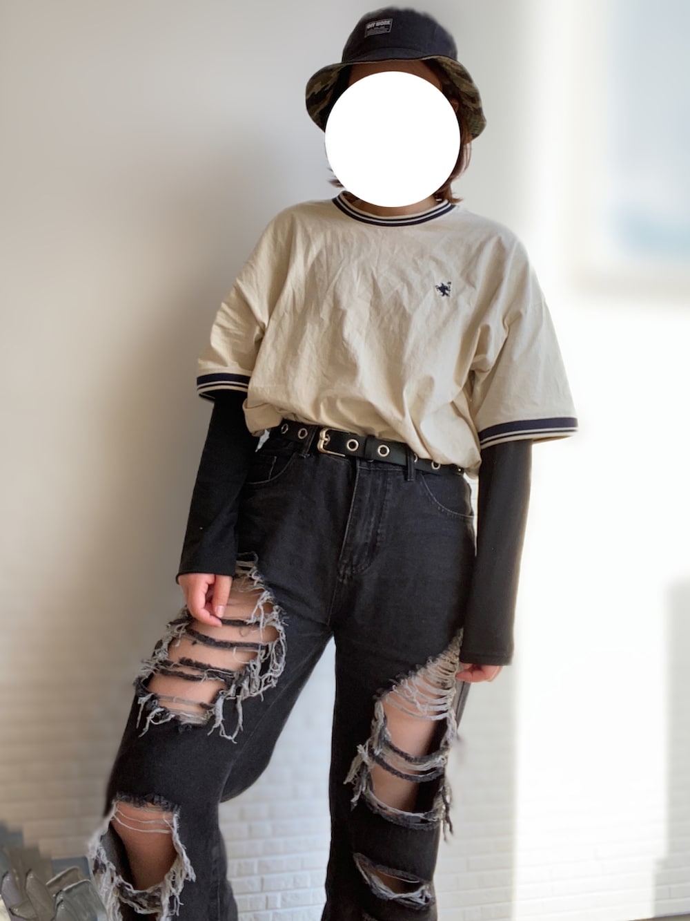 ブラック系のデニムパンツ、ホワイト系のTシャツ/カットソー、ブラック系のサンダルを着用したレディースの春コーディネートの2枚目の写真