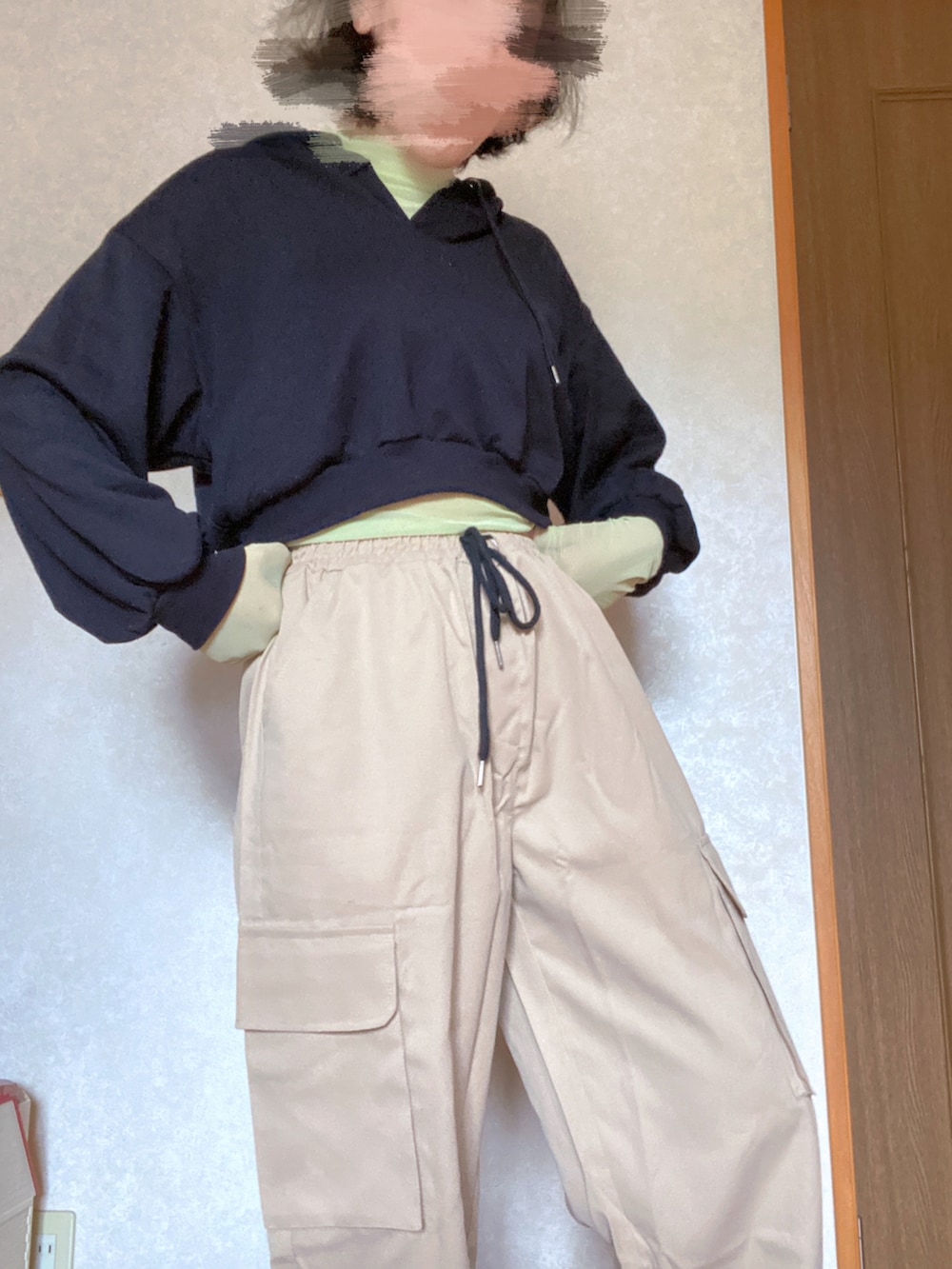 ベージュ系のカーゴパンツ、ブラック系のパーカー、グリーン系のTシャツ/カットソーを着用したレディースの秋コーディネートの3枚目の写真