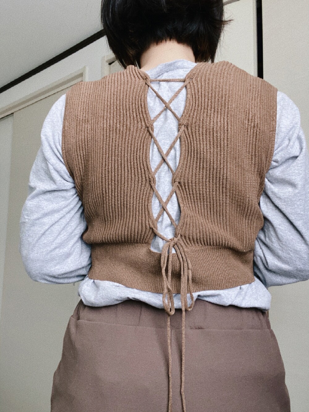 ブラウン系のスラックス、ブラウン系のニット/セーター、グレー系のTシャツ/カットソーを着用したレディースの春コーディネートの3枚目の写真