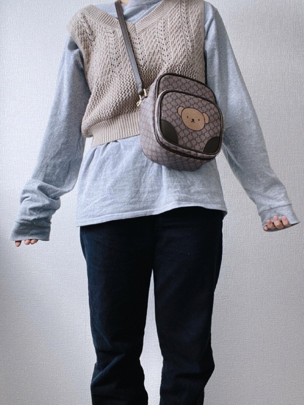 ブラック系のデニムパンツ、グレー系のTシャツ/カットソー、ブラウン系のショルダーバッグを着用したレディースの冬コーディネートの3枚目の写真