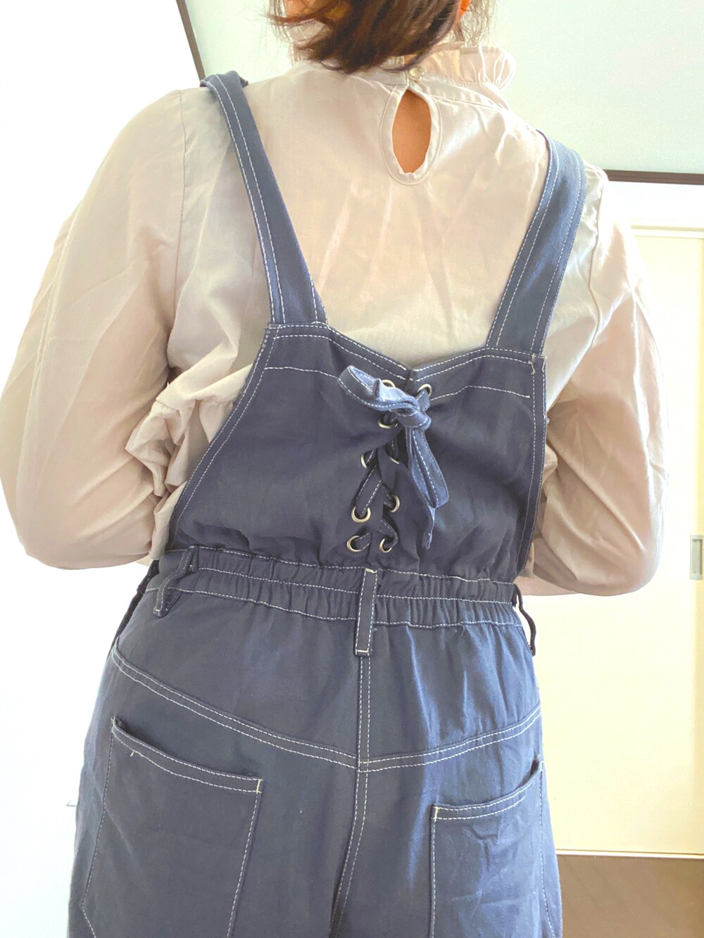 ブルー系のサロペット/オーバーオール、ホワイト系のシャツ/ブラウスを着用したレディースの冬コーディネートの2枚目の写真