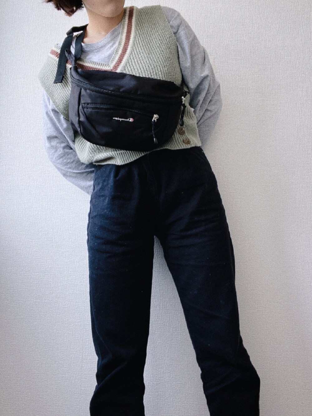 ブラック系のボディバッグ/ウエストポーチ、グリーン系のベスト、グレー系のTシャツ/カットソーを着用したレディースの春コーディネートの4枚目の写真