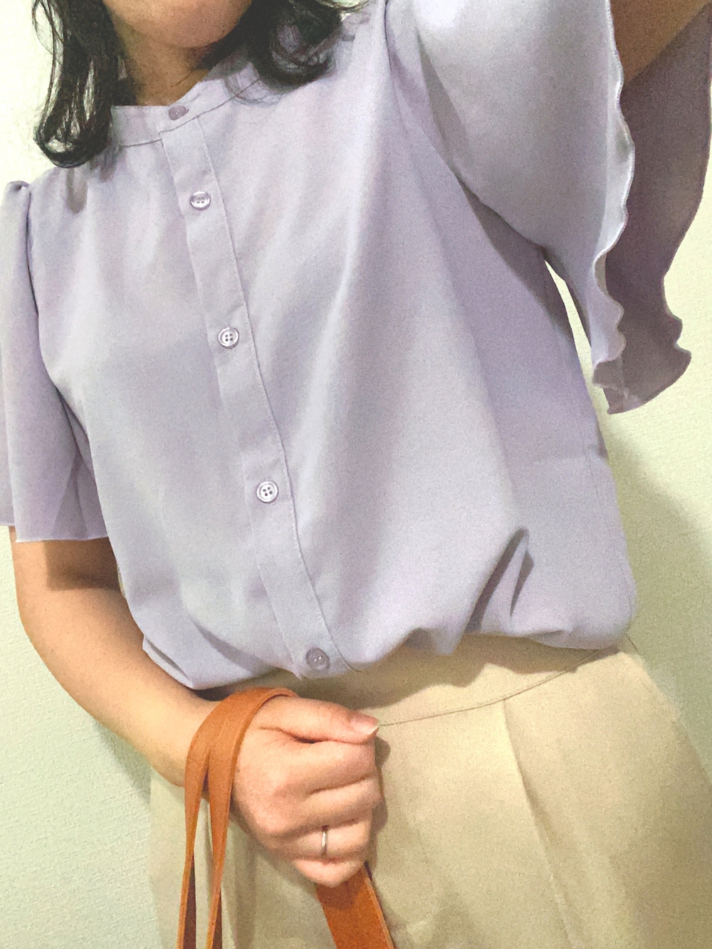 ベージュ系のスラックス、ブルー系のハンドバッグ、パープル系のシャツ/ブラウスを着用したレディースの夏コーディネートの3枚目の写真