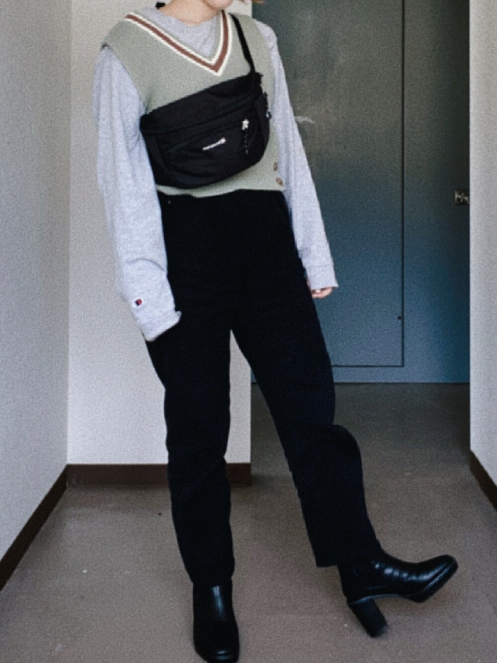 ブラック系のボディバッグ/ウエストポーチ、グリーン系のベスト、グレー系のTシャツ/カットソーを着用したレディースの春コーディネートの3枚目の写真