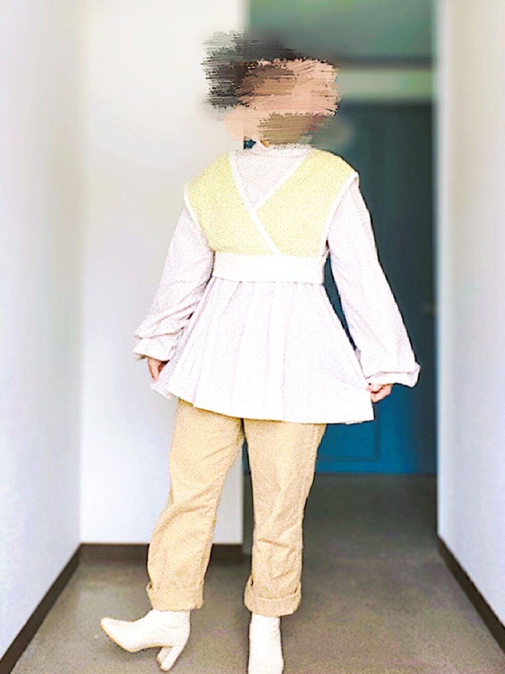 ベージュ系のデニムパンツ、グリーン系のニット/セーター、ベージュ系のワンピースを着用したレディースの春コーディネートの2枚目の写真