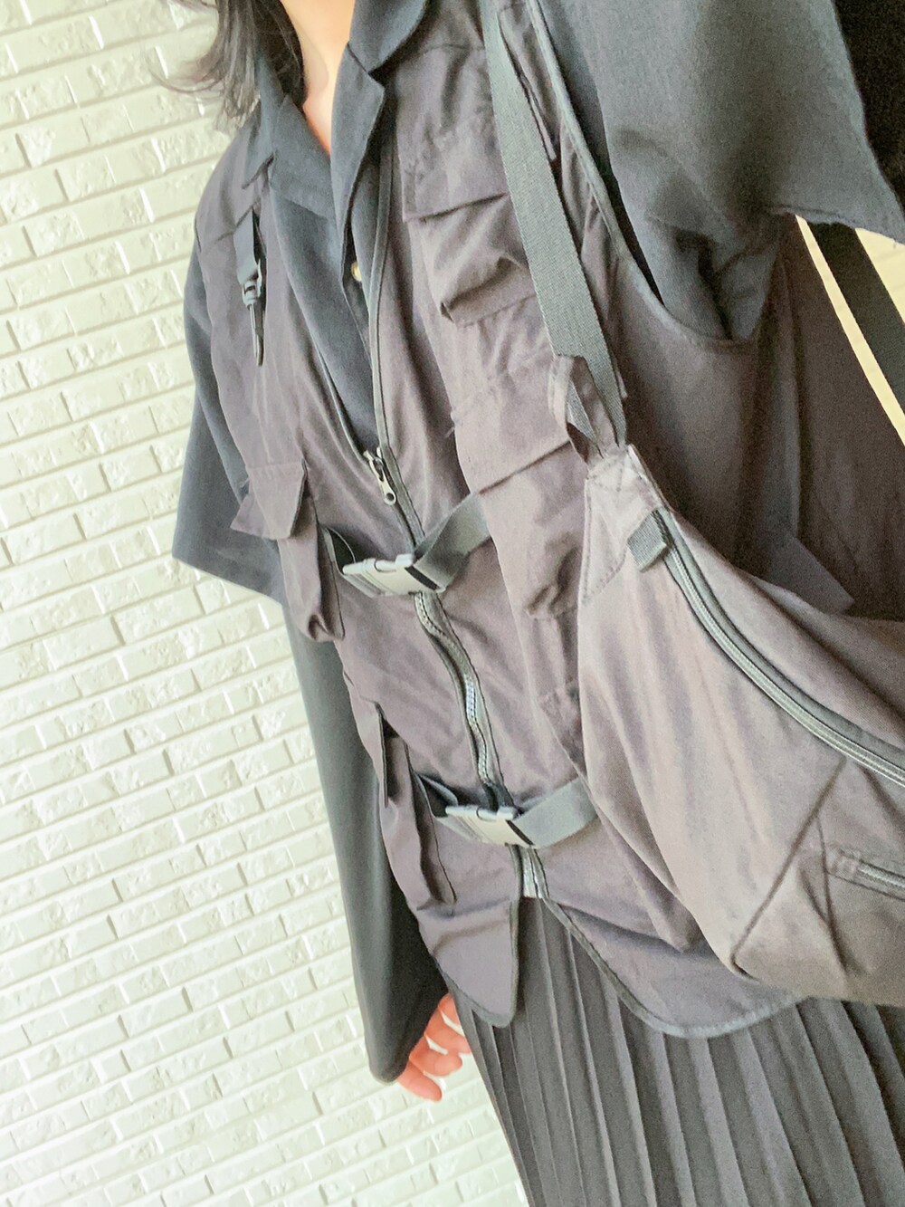 ブラック系のスカート、ブラック系のローファー、ブラック系のボディバッグ/ウエストポーチを着用したレディースの春コーディネートの3枚目の写真