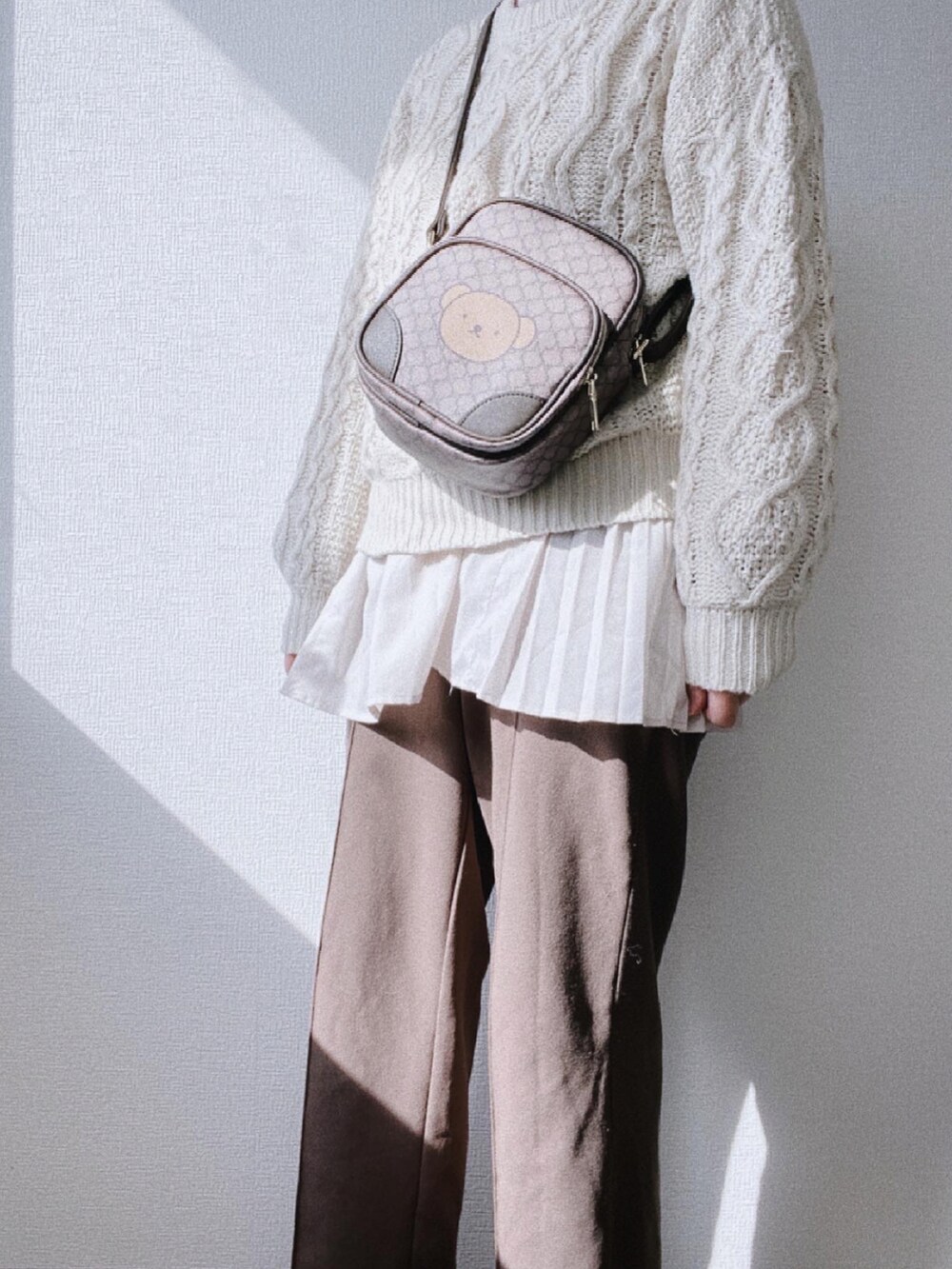 ブラウン系のショルダーバッグ、ホワイト系のニット/セーター、ベージュ系のワンピースを着用したレディースの冬コーディネートの4枚目の写真