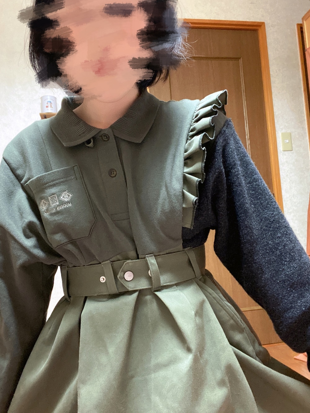 グリーン系のワンピース、ブラック系のブーツを着用したレディースの秋コーディネートの4枚目の写真