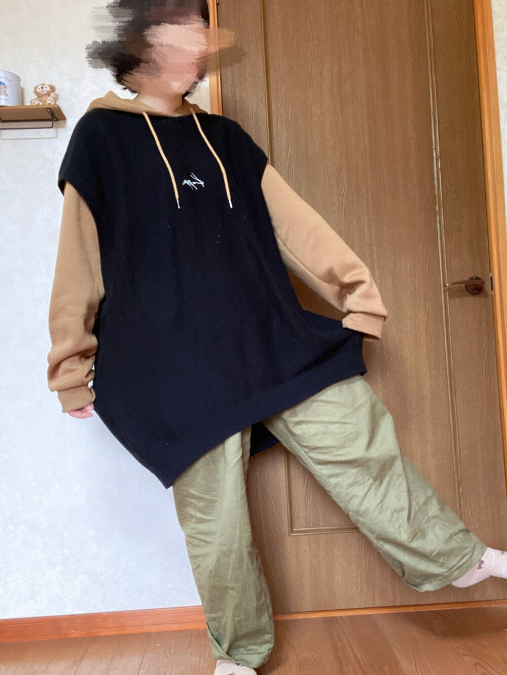 グリーン系のカーゴパンツ、ブラック系のベスト、ブラウン系のパーカーを着用したレディースの秋コーディネートの2枚目の写真