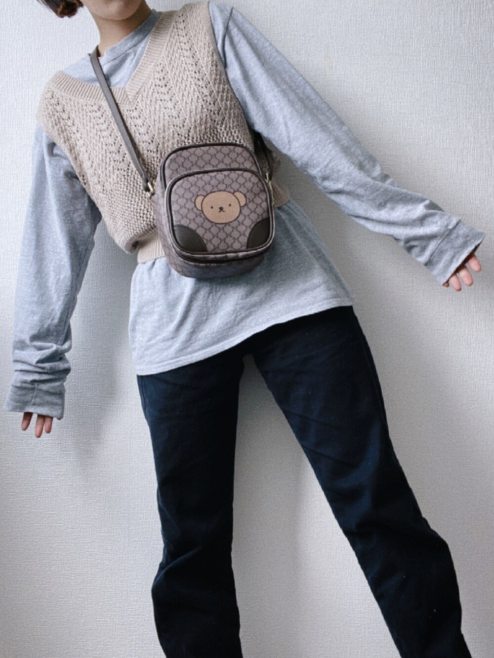 ブラック系のデニムパンツ、グレー系のTシャツ/カットソー、ブラウン系のショルダーバッグを着用したレディースの冬コーディネートの4枚目の写真