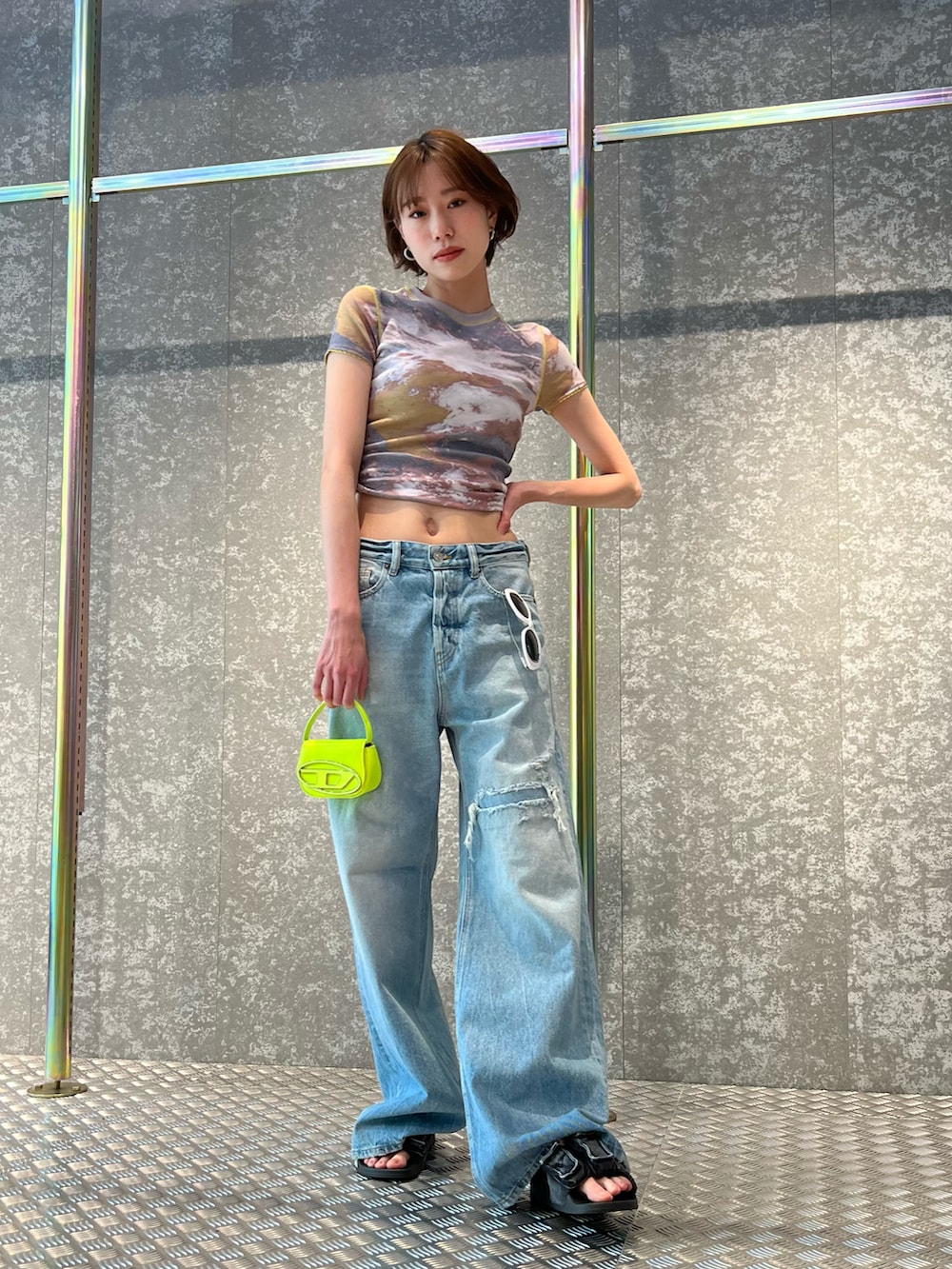 グレー系のTシャツ/カットソー、ブルー系のデニムパンツ、ブラック系のサングラスを着用したレディースの春コーディネートの2枚目の写真